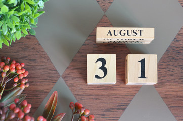 August 31, Number Cube with a flower leaves and bush on Diamond wood table for the background.