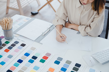 Fashion designer drawing a new clothes model on the paper.