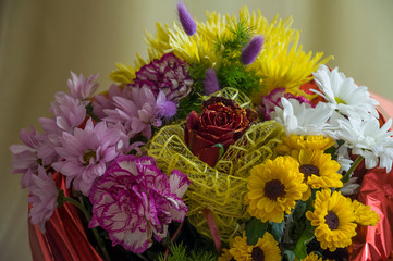 Flowers of different colors  in the bouquet on the background of green curtain. Rose, chrysanthemum, aster, carnation