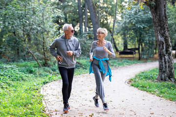 Mature couple man and woman jogging in the park