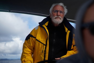  White bearded sailing senior, experienced skipper on a sailboat