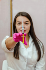 female doctor holds medical syringe in front of her