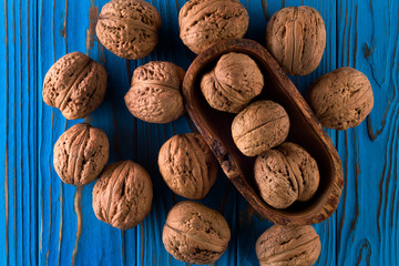 Wall Mural - Top view photo of whole walnuts on painted blue wooden table