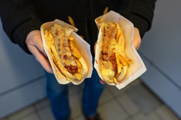 man holding two special icelandic hot dogs