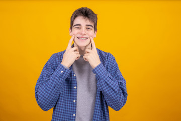 young teenager boy or student isolated on yellow background