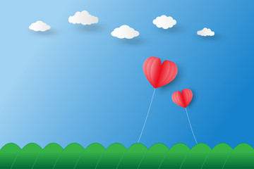 Poster - two red heart shaped balloons  float on blue sky under white clouds and over mountain