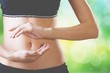 Beautiful woman's slim stomach, using hands she is showing a balance in her microflora
