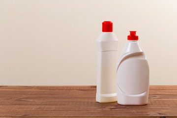 Cleaning product plastic container for house clean on wooden table and gray background . household chemicals