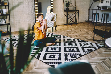Fototapete - Young guy doing yoga in padmasana on floor