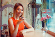 © hbrh - Portrait of a girl using the voice recognition of the phone and looking at cell phone near a window of a house, coffee shop