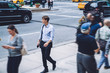 © BullRun - Confident businessman holding bag walking on street