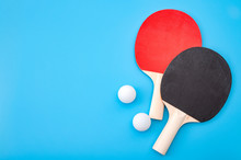 Pingpong Lesson And Winning Competitive Challenge Concept With Red And Black Table Tennis Or Ping Pong Paddle Isolated On Blue Background With Copy Space