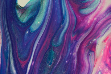 This colorful macro photograph of an abstract acrylic pour painting features swirls of classic blue, metallic teal, neon pink, dark purple, black, and white for backgrounds.