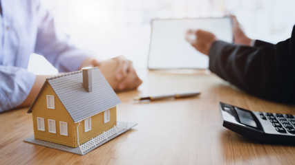 Side view of House loan agent holding  blank screen tablet presenting to customer