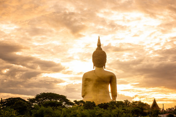 Wall Mural - Makha Bucha Day, Visakha Bucha, a large shadow Buddha statue behind a golden sunset in Thailand