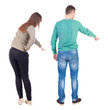 © ghoststone - Back view of couple couple in sweater pointing.