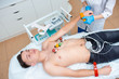 © salomonus_ - Cardiogram of the heart. Cardiologist attaches electrodes of an electrocardiograph to a young man. Cardiology