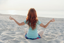 Young Woman Meditating On A Tropical Beach
