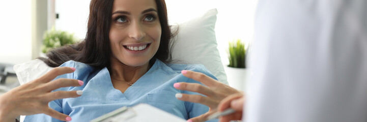 Canvas Print - Portrait of smiling woman speaking about illness and diagnosis with professional doctor. Lovely model looking at nurse with gladness. Healthcare and medicine concept