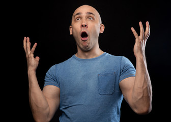 Wall Mural - Photo of surprised bald man in blue tee shirt