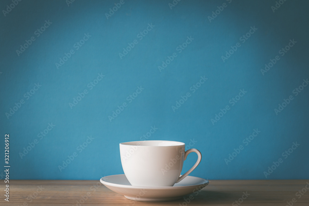 cup of coffee on wooden table with blue background