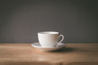 cup of coffee on wooden table with grey background