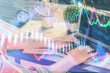 © peshkova - Double exposure of stock graph with businessman typing on computer in office on background. Concept of hard work.