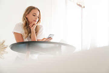 Poster - Woman indoors at home using mobile phone.