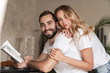 © Drobot Dean - Optimistic loving couple reading book.
