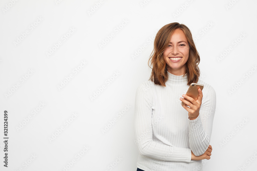portrait of young beautyful woman on the phone looks in camera - obrazy, fototapety, plakaty 
