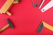 carpentry tools on a red background flat lay with copy space