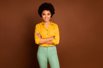 Wall Mural - Photo of stunning business dark skin curly lady looking colleagues good mood arms crossed friendly smiling wear yellow shirt green pants isolated brown color background