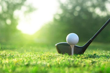 Golf clubs and golf balls on a green lawn in a beautiful golf course