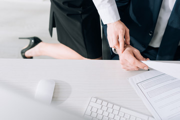 cropped view of secretary touching hand of businessman in office