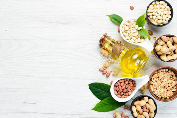 Wall Mural - Peanut oil. in jar on wooden background. Top view.