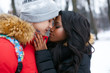 Beautiful afro american woman hugging with a white man on a winter day. Tenderness. Interracial relationship of a young couple.