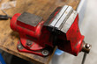 Metal large red vise with aluminum jaws.