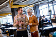 © BGStock72 - Senior business woman and her young colleague standing in office with digital tablet
