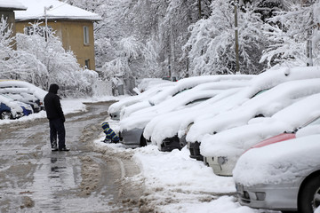 People look at covered with heavy snow after snowstorm in winter