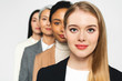 © LIGHTFIELD STUDIOS - selective focus of four attractive and multicultural businesswomen looking at camera isolated on white