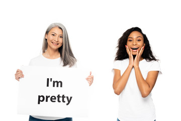 Wall Mural - happy african american and asian women near i`m pretty placard isolated on white