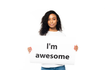 Wall Mural - smiling african american woman holding placard with i`m awesome lettering isolated on white