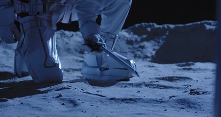 astronaut using equipment to collect samples