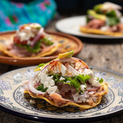 Wall Mural - Mexican ham toast also called tostadas with beans and cheese on wooden background