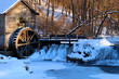 Rural landscape with old abandoned watermill in woods. Snowy winter view of obsolete wooden mill and waterfall between trees in sunlight. Travel America, Wisconsin, Midwest USA.