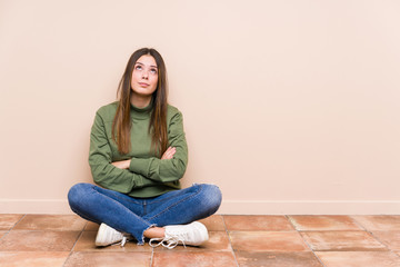 Wall Mural - Young caucasian woman sitting on the floor isolated tired of a repetitive task.