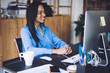 © BullRun - Smiling black lady in earphones looking at computer screen