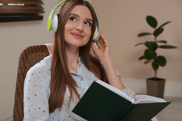 Wall Mural - Woman listening to audiobook in chair at home