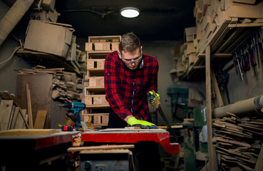 Wall Mural - Craftsman using hand saw in wood workshop