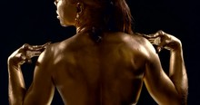 Black Female Culturist Is Showing Her Muscular Back And Shoulders In Dark Room